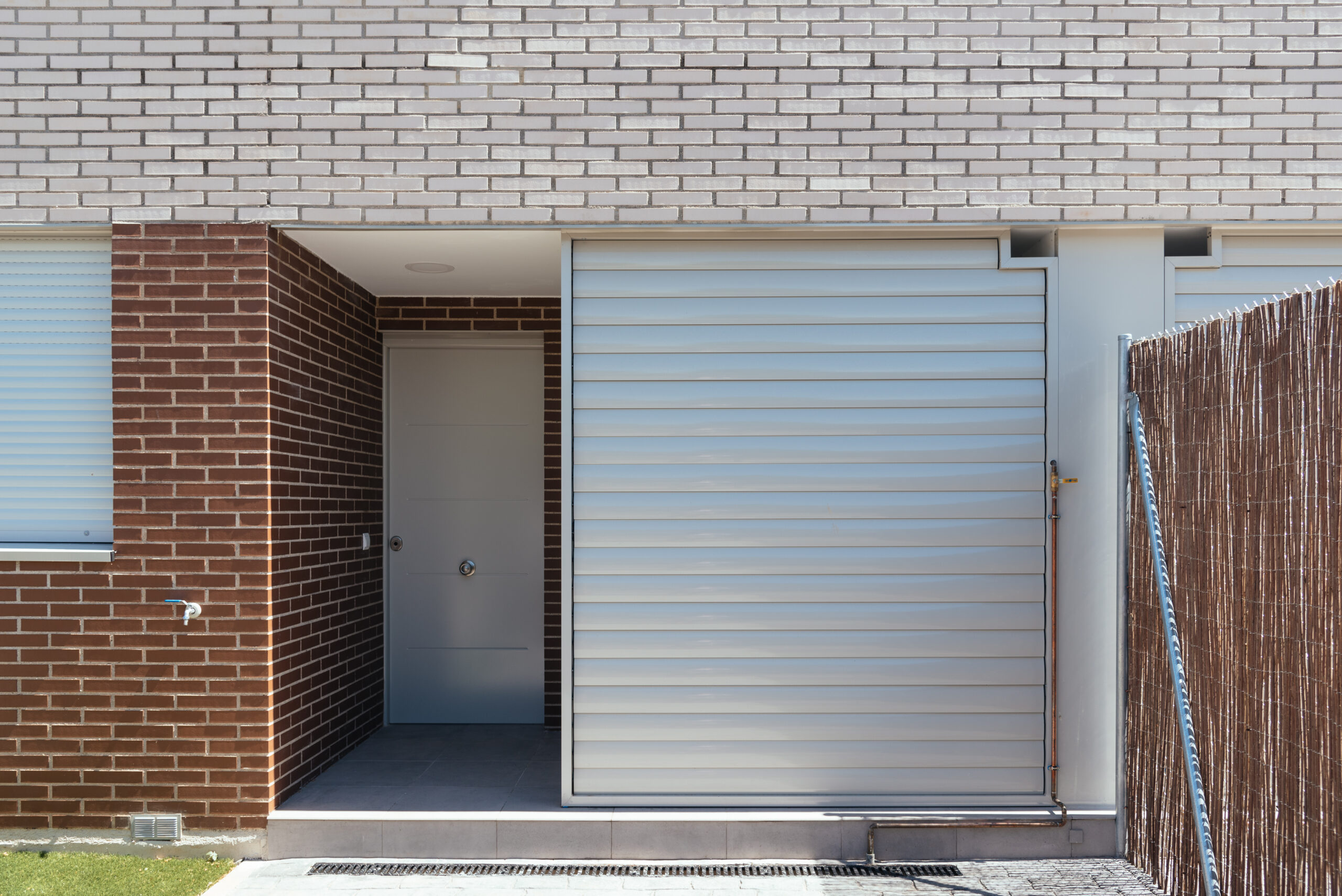 Electric Roller Doors 3 exterior view modern semi detached townhouses with brick facade sunny day scaled